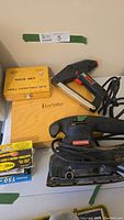 Photo of Craftsman sander, electric stapler, Lee Valley chisel set wooden box, and drill bit set with staples box