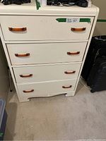 Front view of vintage dresser showing four white drawers with amber handles, displaying light wear and seller's lot number.