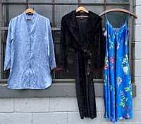 Front view of the vintage Jones New York sleepwear lot showing the periwinkle blue satin button-down night shirt, the black faux fur plush bathrobe, and the bright cerulean blue slip dress with butterfly and flower print.