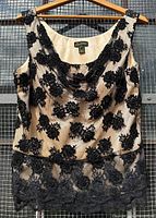 Front view of the black beaded floral lace evening top on cream mesh, showing cowl neck and lace hem detail.