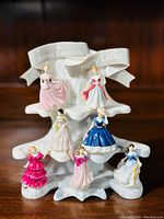 Full front view of the Royal Doulton Pretty Ladies miniatures arranged on the original stand