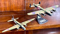 Models displayed on wooden shelf, showing both planes and stand labeled Vickers-Armstrongs