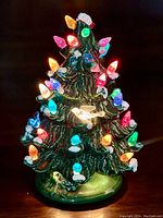 Close-up photo of the ceramic Christmas tree lit up in the dark showing colorful vibrant multi-colored lights.