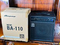 Combo amplifier and its original Ampeg BA-110 box side by side showing the unit and packaging.