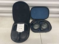 Both sets side by side in their open carrying cases showing exterior finishes