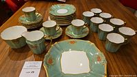 Photo of entire set showing cups, saucers, dessert plates, cream and sugar, and two large serving plates laid on table
