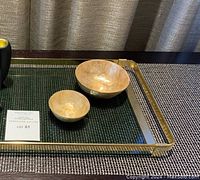 Photo shows a close-up of the brass tray with two hammered brass bowls placed on it, all on one of the gold vinyl placemats.