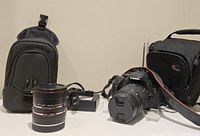 Overview of camera body with attached kit lens, extension tubes, charger, neoprene pouch and Lowepro bag