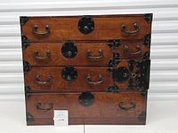 Front view of Korean-style wooden chest with four tiers of drawers and black metal hardware
