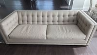 Front view of full sofa showing tufted back and seat cushions