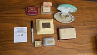 Top-down photo of eight assorted vintage jewelry and ring boxes grouped on a wooden surface