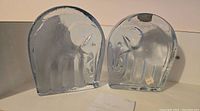 Pair of clear vintage Blenko glass elephant bookends with textured icy surfaces and visible stylized elephant shapes.