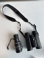 Both the Nikon binoculars and monocular shown with neck straps.