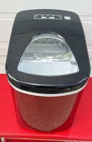 Front view showing red metallic body with black plastic top with window for ice viewing and control buttons