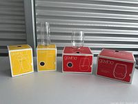 Four boxes with two transparent plastic glasses placed on top, showing two types of glasses in the lot.