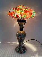 Lit lamp full view showing shade, base, cord and hardware