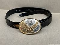 Full view of the black leather belt and attached Montana Silversmiths buckle showing eagle and ornate design