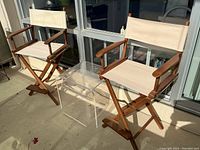 Pair of folding director chairs side by side on balcony