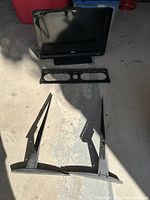 Sony Bravia TV with mount horizontal bracket and two vertical brackets laid on floor.