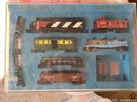 Blue tray with Bachmann HO scale train cars and curved track pieces in the original packaging