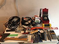 View of assorted handheld tools, batteries, and the drill showing the lot's content and condition.