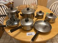 Overview of all stainless steel cookware items arranged on table