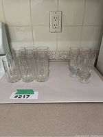 Eight tall cylindrical Mikasa drinking glasses with vertical cut-glass pattern.