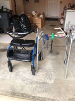 Wide view of two walkers and two adjustable canes in a garage setting.