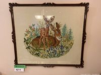 Front view of needlepoint wall art showing entire framed embroidery of two deer in a floral natural scene.