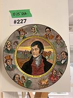 Frontal view of Royal Doulton Robbie Burns decorative plate with central portrait and surrounding character faces, showing artwork and condition.