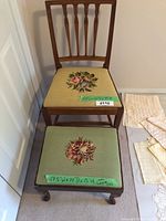 Full view of wooden chair with yellow needlepoint floral cushion and matched wooden footrest with green floral needlepoint cushion placed in front.