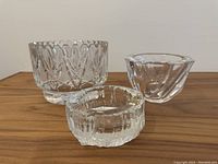 Three vintage crystal bowls grouped, showing different shapes and patterns: a heavy cut lead crystal bowl, a clear smooth Orrefors bowl, and a thick clear cut bowl
