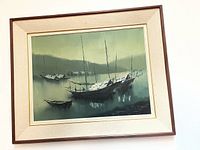 Front view of framed oil painting depicting Chinese boats with misty green and gray background.