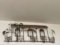Full view of vintage metal wall art cafe scene showing tables, chairs, windows, and awning.