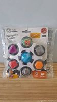 Front view of Baby Einstein Curiosity Clutch baby toy in original packaging showing colorful parts and shapes.