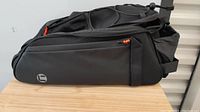 Side view of the black bike travel sack showing large side zipper pocket and durable material.