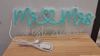 Full view of the 'Mr & Mrs est. 2024' light up LED sign on a wooden surface, showing cables and clear backing.