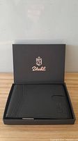 Black Zitahli men's wallet in box showing front and embossed logo.