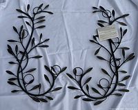 Pair of Bombay and Company metal wall votive holders laid on white fabric.