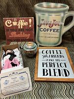 Lot contents showing coffee decor signs, lusterware sugar bowl, and Royalton Collection doll in box with certificate