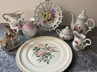Lot showing all porcelain items including the tea set, decorative plates, pitchers, and the figurine