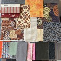 Top-down photo showing full assortment of fabric pieces in various colors and patterns spread out on table