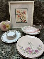 Full view of lot including framed floral artwork, Nippon vase, Taylor Smith Taylor and Haviland plates and bowls on patterned textile background