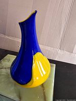 Side-angle view showing the blue and yellow color combination with the distinctive twisted shape.