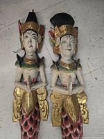 Front view of the two hand carved Balinese mermaid statues with detailed painted and gilded features.