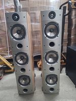 Front view of two PSB Image T65 tower speakers showing maple veneer and grey baffles with drivers