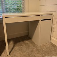 Closed view of white computer desk showing right-side cabinet and drawers.