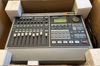 Roland VS-880 Digital Studio Work Station showing the front panel with sliders, knobs, buttons, and screen in protective foam packaging.