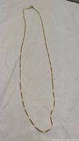Full length of necklace laid flat on white background