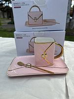 Photo showing one ceramic cup, rectangular plate and a small gold spoon, with product boxes behind showing brand Mingyi and design.